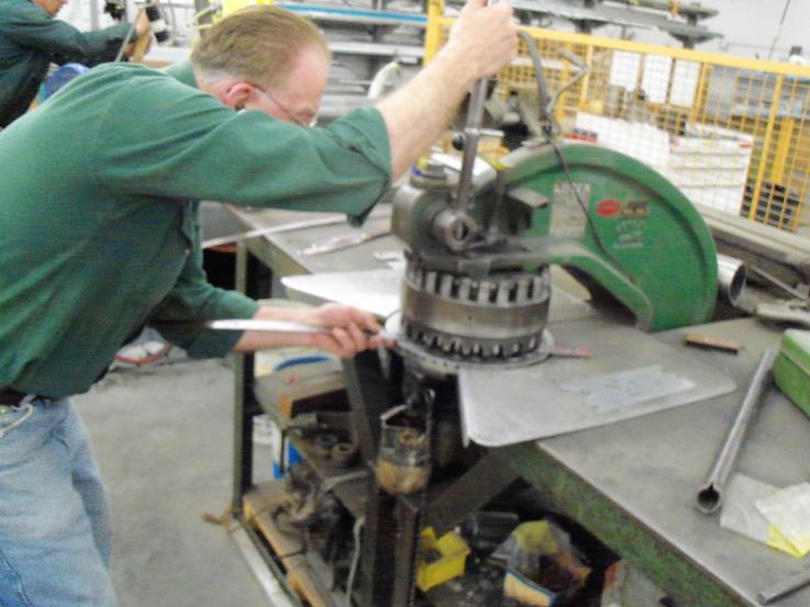 Adding holes to the copper luggage straps using a drill press.